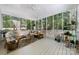 Inviting screened porch featuring comfortable seating, a ceiling fan, and views of the lush backyard at 480 Robinson Rd, Mooresville, NC 28117