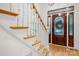 Close-up of staircase with wood treads, white risers, and an elegant stained-glass front door visible in the background at 480 Robinson Rd, Mooresville, NC 28117