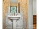 Cozy half bathroom featuring pedestal sink and decorative wallpaper at 5126 Unaka Ave, Charlotte, NC 28205