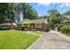 Quaint single-story home with a lush green lawn, brick siding, and a long driveway at 5126 Unaka Ave, Charlotte, NC 28205