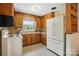 The kitchen features knotty pine cabinets, white appliances, and linoleum flooring at 5126 Unaka Ave, Charlotte, NC 28205