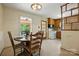 Eat-in kitchen features warm wood cabinets, white appliances, and adjacent breakfast nook with wooded views at 5126 Unaka Ave, Charlotte, NC 28205