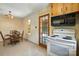 An eat-in kitchen boasts wood cabinets, linoleum flooring, and white appliances at 5126 Unaka Ave, Charlotte, NC 28205