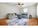 Cozy living room featuring hardwood floors, comfortable sofas, and a ceiling fan for added comfort at 5126 Unaka Ave, Charlotte, NC 28205