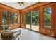 The sunroom is surrounded by windows offering views of the deck and wooded backyard at 5126 Unaka Ave, Charlotte, NC 28205