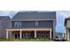 Two-story home featuring dark siding, white trim, and a covered porch with white columns, offering a blend of style and comfort at 638 Amberjack Pl # 76, York, SC 29745