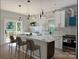 Modern kitchen with white cabinets, marble backsplash, large island, pendant lighting, and sliding doors to a deck at 908 30Th Avenue Nw Dr # 2, Hickory, NC 28601