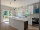 Modern kitchen with white cabinets, marble backsplash, large island, pendant lighting, and view to a deck at 908 30Th Avenue Nw Dr # 2, Hickory, NC 28601