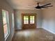 Bright open-concept living room featuring light grey walls, wood floors, large double doors, and many windows at 908 30Th Avenue Nw Dr # 2, Hickory, NC 28601