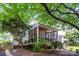 Landscaped backyard featuring a screened-in porch, patio, and mature trees at 10230 Blackstock Rd, Huntersville, NC 28078