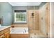 This bathroom features a soaking tub and glass-enclosed shower with tiled walls at 10230 Blackstock Rd, Huntersville, NC 28078