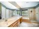 A bright bathroom features double sinks, a soaking tub, and a glass-enclosed shower for spa-like experience at 10230 Blackstock Rd, Huntersville, NC 28078