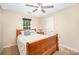A sunlit bedroom features a wooden bed frame, ceiling fan, and neutral-toned walls at 10230 Blackstock Rd, Huntersville, NC 28078