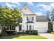 Charming two-story home with white siding, black shutters, and a well-manicured front yard with mature trees at 10230 Blackstock Rd, Huntersville, NC 28078