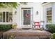 Close-up of the front door entrance with a black door and a small brick porch, adorned with a wreath and seating at 10230 Blackstock Rd, Huntersville, NC 28078