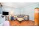 Cozy living room with hardwood floors, a gray sectional couch, and a TV, creating a comfortable space at 10230 Blackstock Rd, Huntersville, NC 28078