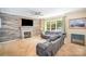 Bright living room with a decorative fireplace, cozy seating, and a large window providing natural light at 10230 Blackstock Rd, Huntersville, NC 28078
