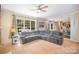 Spacious living room with a plush sectional couch and large windows overlooking a serene outdoor setting at 10230 Blackstock Rd, Huntersville, NC 28078