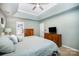 A soothing bedroom offers comfort with a tray ceiling, neutral tones, and wooden dressers at 10230 Blackstock Rd, Huntersville, NC 28078