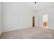 Large vacant bedroom has neutral carpet, white walls, vaulted ceilings, with access to ensuite bath at 10303 Dominion Village Dr, Charlotte, NC 28269