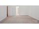 Spacious vacant bedroom features neutral walls and carpeting, as well as an entryway to another room at 10303 Dominion Village Dr, Charlotte, NC 28269