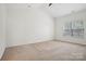 Bright bedroom offers a large window, neutral carpeting, and vaulted ceiling at 10303 Dominion Village Dr, Charlotte, NC 28269