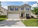 Charming two-story home featuring a two-car garage, landscaped yard, and inviting front porch at 10303 Dominion Village Dr, Charlotte, NC 28269