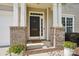 Inviting front porch with brick accents and potted flowers provides a warm welcome at 10303 Dominion Village Dr, Charlotte, NC 28269