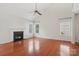 Living room with hardwood floors and a cozy fireplace, surrounded by bright natural lighting at 10303 Dominion Village Dr, Charlotte, NC 28269