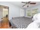 Cozy bedroom featuring hardwood floors, a ceiling fan, and a bright window, creating a peaceful retreat at 1033 Rollingwood Dr, Charlotte, NC 28217