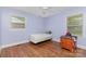 Bedroom with hardwood floors, two windows, a ceiling fan, and a light purple color scheme at 1033 Rollingwood Dr, Charlotte, NC 28217