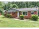Charming single-story brick home with mature landscaping and a welcoming front porch, perfect for a cozy lifestyle at 1033 Rollingwood Dr, Charlotte, NC 28217