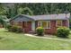 Charming single-story brick home with mature landscaping and a welcoming front porch, perfect for a cozy lifestyle at 1033 Rollingwood Dr, Charlotte, NC 28217