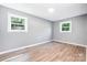 Bright bedroom featuring two windows, light gray walls, and light wood-look flooring at 1048 Shenandoah Dr, Gastonia, NC 28052