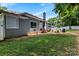 Spacious backyard with a lush green lawn, fence, mature trees, and patio with playset and BBQ grill at 13517 Silver King Ct, Huntersville, NC 28078