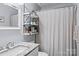 Bathroom featuring granite vanity, shower with curtain, shelving, well lit mirror and neutral decor at 13517 Silver King Ct, Huntersville, NC 28078