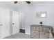 Well-lit bedroom with a dresser, mirror, ceiling fan and a view into another room providing a comfortable retreat at 13517 Silver King Ct, Huntersville, NC 28078