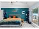 Stylish bedroom featuring a turquoise accent wall, unique decor, and a window with natural light at 13517 Silver King Ct, Huntersville, NC 28078