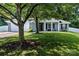 Charming one-story home with a well-manicured lawn and inviting front porch with white columns and mature trees at 13517 Silver King Ct, Huntersville, NC 28078