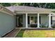 Inviting front porch with stately white columns, neutral brick, black shutters and a green chair set at 13517 Silver King Ct, Huntersville, NC 28078