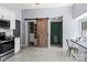 Modern kitchen featuring a sliding barn door, stainless steel appliances, and adjacent breakfast table at 13517 Silver King Ct, Huntersville, NC 28078