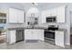 Well-lit kitchen boasts stainless steel appliances, granite countertops and white cabinetry at 13517 Silver King Ct, Huntersville, NC 28078