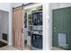 Convenient laundry area with stacked washer and dryer behind a decorative sliding barn door at 13517 Silver King Ct, Huntersville, NC 28078