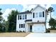 Two story home featuring a white exterior, black shutters, a covered front porch, and an attached garage at 1683 Interstate View Dr, Gastonia, NC 28052