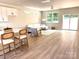 Open-concept living room featuring a white sofa, natural light, and modern finishes, adjacent to the kitchen island at 1683 Interstate View Dr, Gastonia, NC 28052