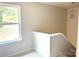 Bright staircase landing featuring neutral walls, carpet, a window with a view, and modern light fixture at 1683 Interstate View Dr, Gastonia, NC 28052
