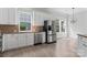 Kitchen features stainless steel appliances, granite counters, white cabinets, and lots of natural light at 17514 Harbor Walk Dr, Cornelius, NC 28031