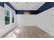 Bright and spacious living room with natural light, modern light fixture and white wainscoting at 17514 Harbor Walk Dr, Cornelius, NC 28031