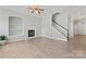 Living room features hardwood floors, fireplace, built-in bookshelves, ceiling fan and staircase at 17514 Harbor Walk Dr, Cornelius, NC 28031