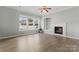 Living room has hardwood floors, fireplace, built-in bookshelves, ceiling fan and large windows at 17514 Harbor Walk Dr, Cornelius, NC 28031